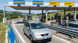 Auto in transito a un casello autostradale con corsie Telepass e carte